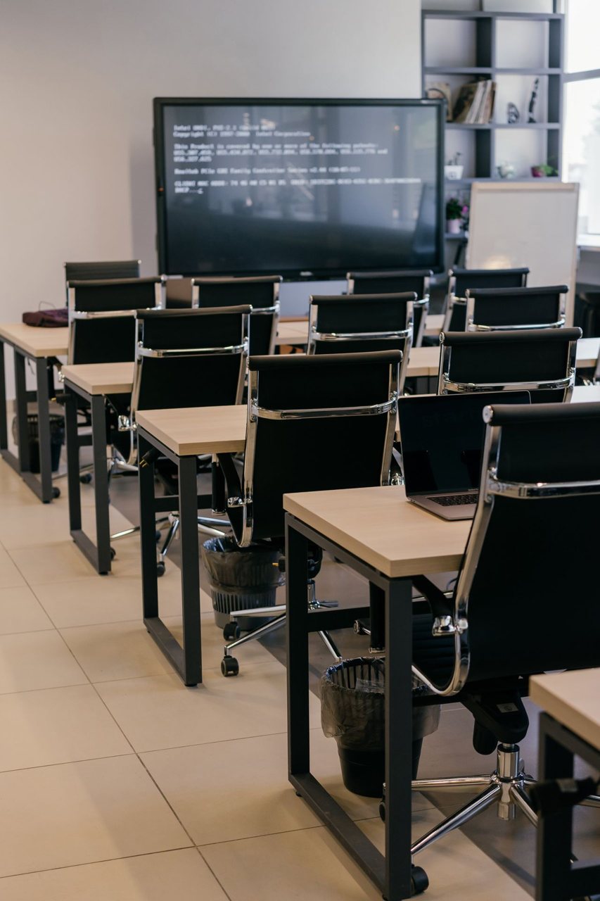 Free Contemporary office space with sleek black leather chairs and a large screen for presentations. Stock Photo