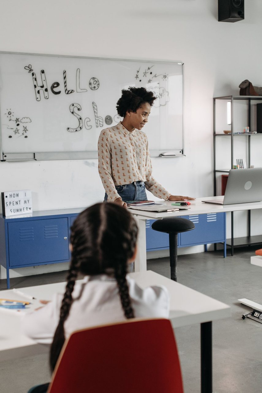 Free A teacher engaging students in a modern classroom, discussing a new school year. Stock Photo